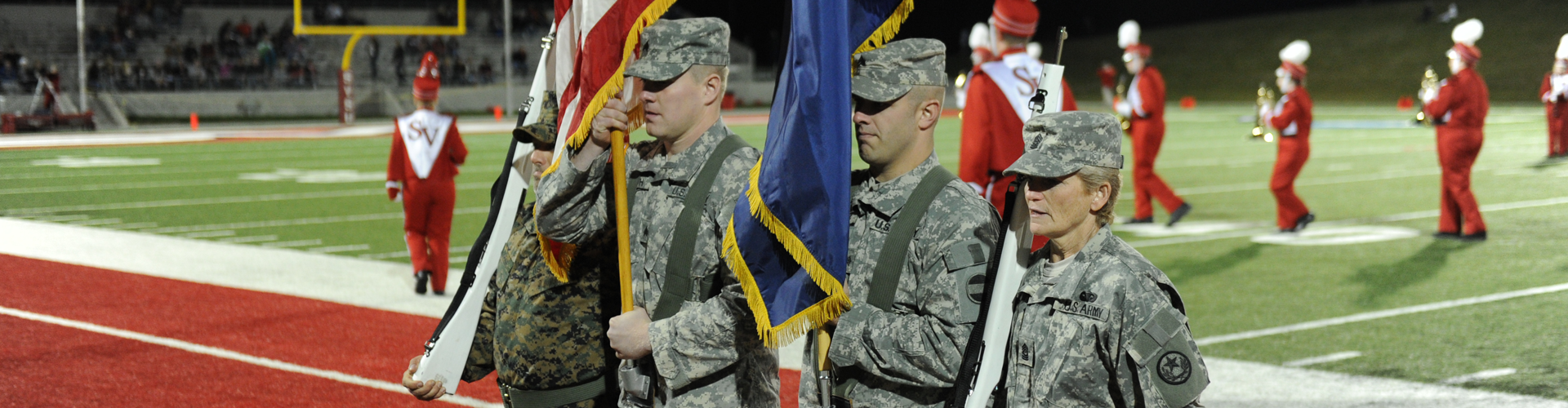 Military members carry flags before a SVSU football game