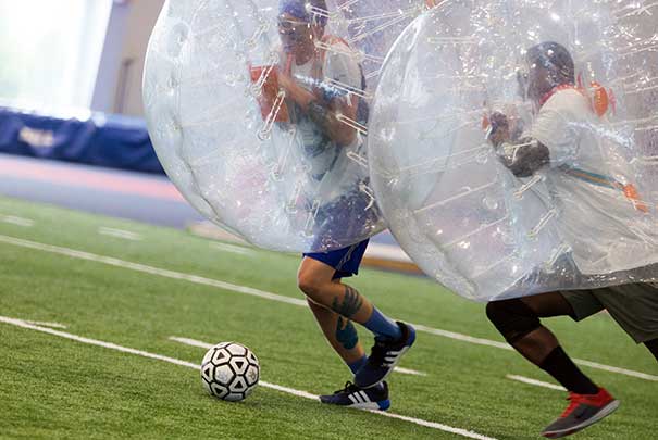 students playing blow up soccer in the field house