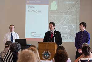 Andrew Miller, SVSU associate professor of geography, presents research showing blight removal in Saginaw has contributed a drop in crime in the city and its neighbors. Miller spoke at the Reinventing Saginaw symposium at the Bancroft building in downtown Saginaw May 26, 2015.
