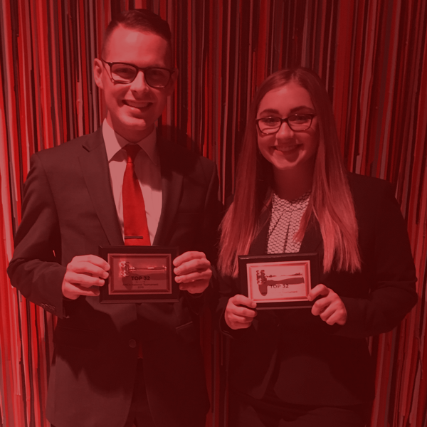 A pair of Moot Court students holding awards from competition