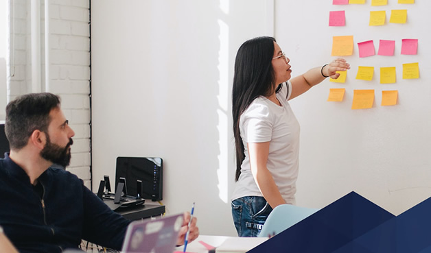 Team member at whiteboard designing idea flowchart