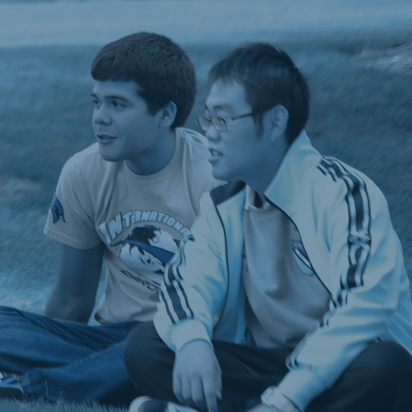 two boys sitting on campus