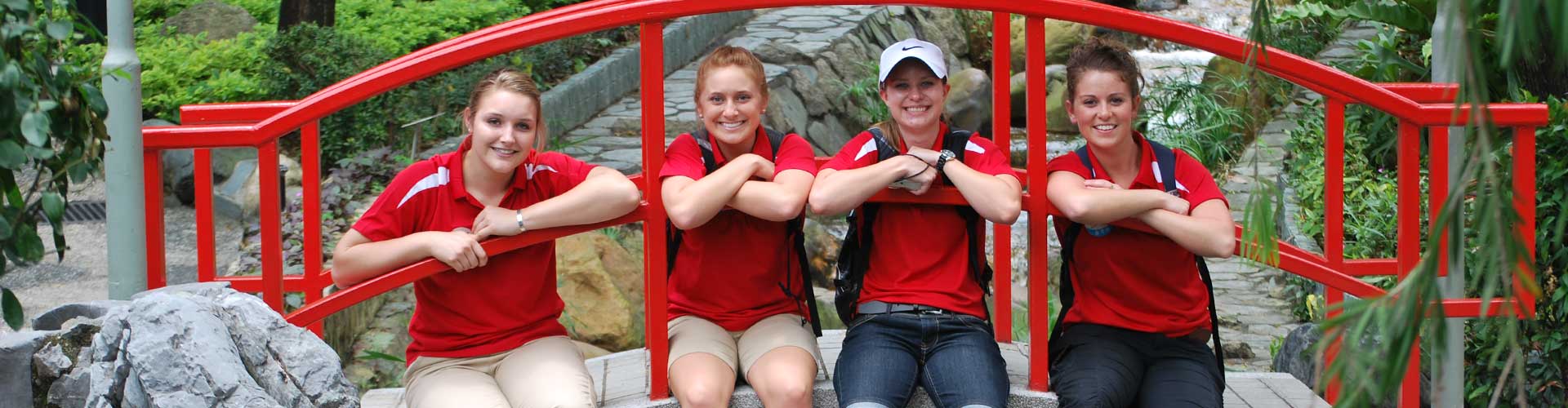 Students sitting on a red bridge in China